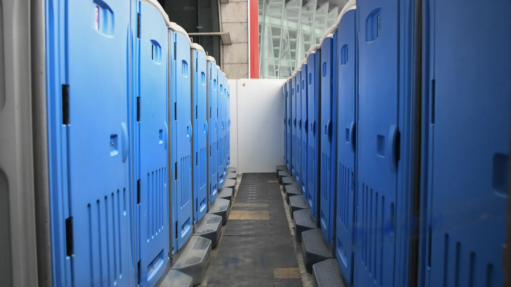 Fila de baños químicos azules instalados en una obra